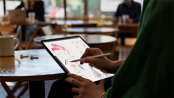 Persona diseñando en una cafetería usando un Apple Pencil 