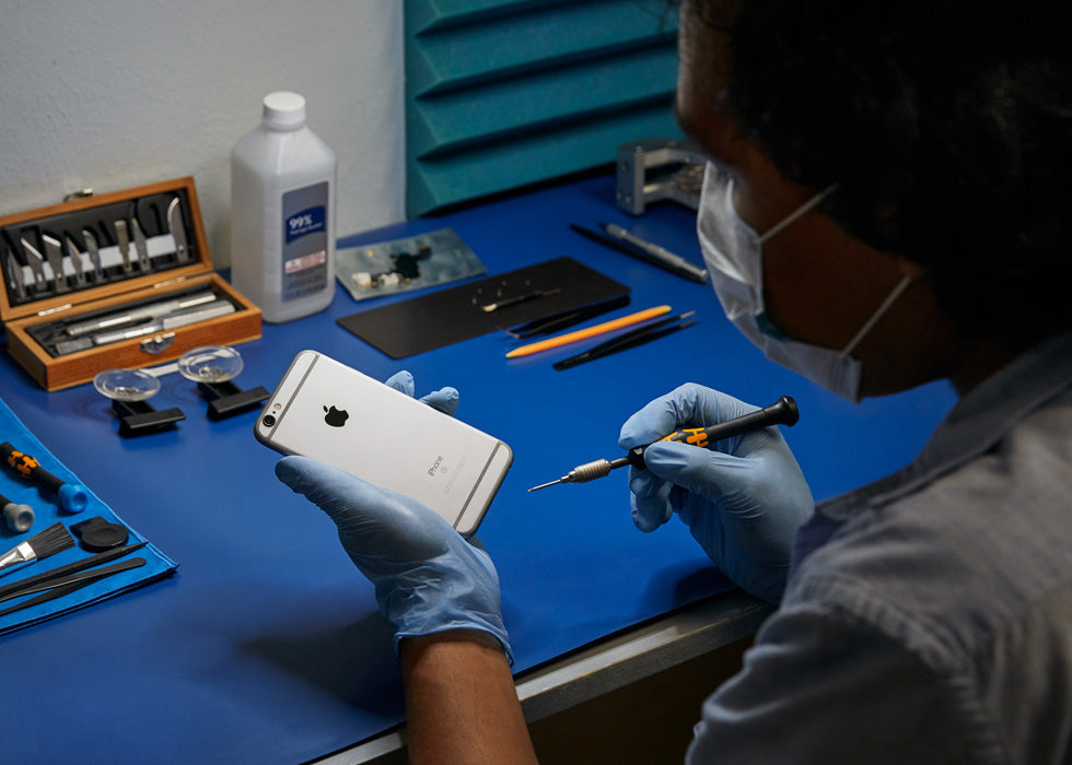 Un experto certificado por Apple revisa un iPhone para cambiar su batería en el servicio técnico de Mac Center