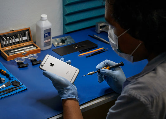 Un experto certificado por Apple revisa un iPhone para cambiar su batería en el servicio técnico de Mac Center