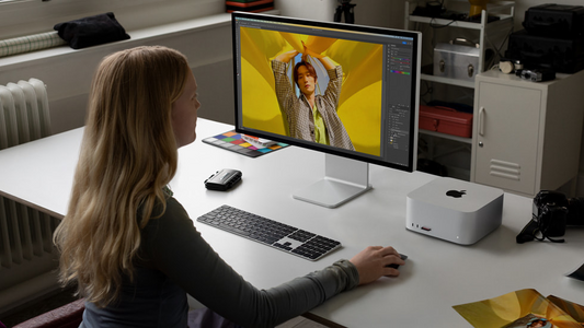 Mujer realiza trabajos creativos en un Mac Studio y Studio Display